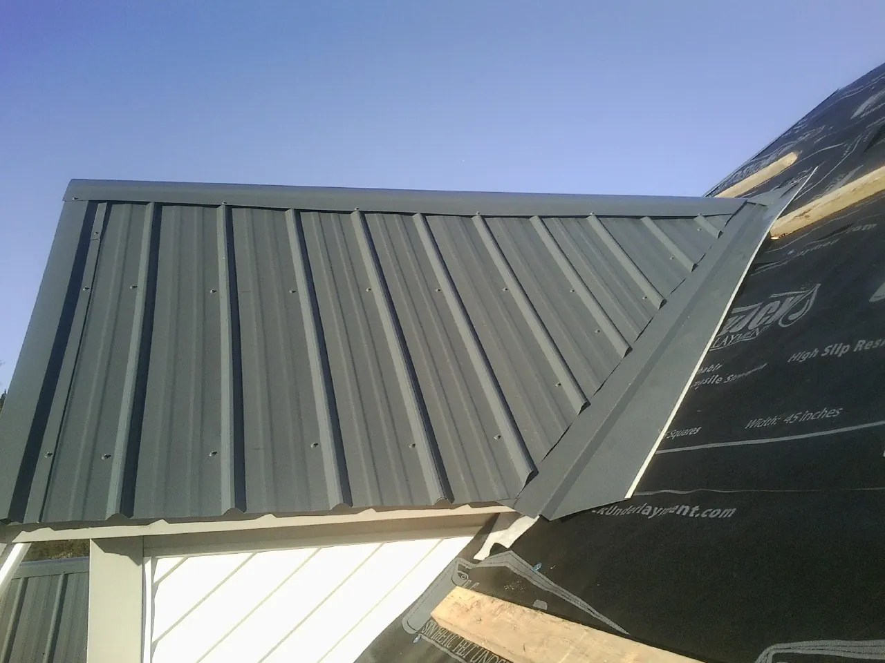 Gray metal roof panels going on over a garage gable in Petersburg